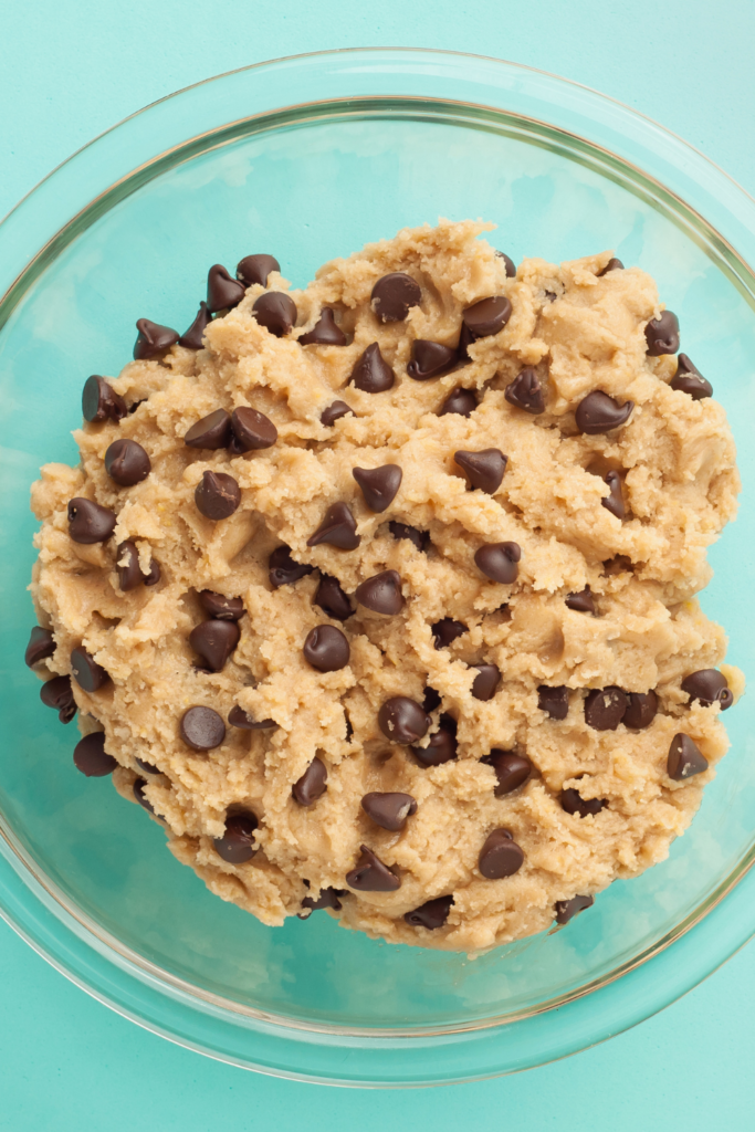 cookie dough in glass bowl with teal background
