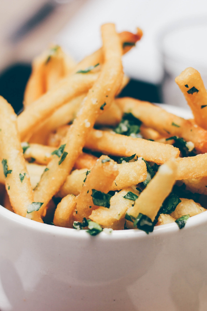 french fries in bowl with fresh herbs