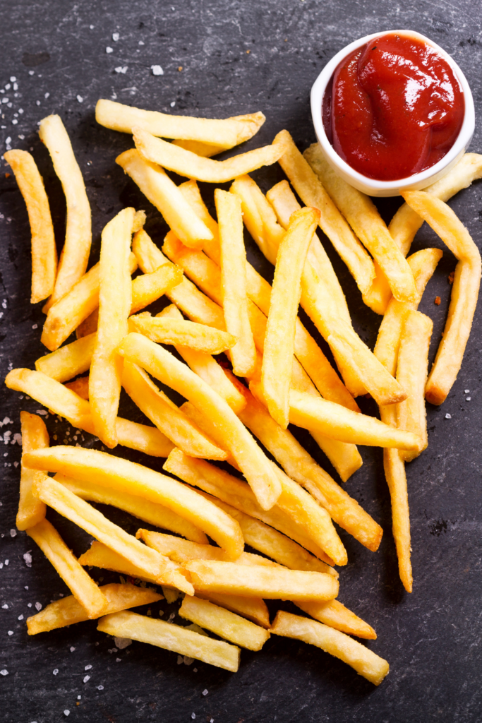 fries on a black backdrop with ketchup