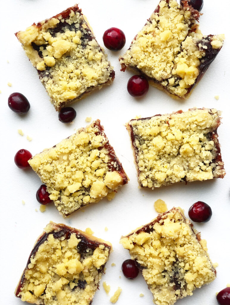 cranberry pie bars on a white background with fresh cranberries