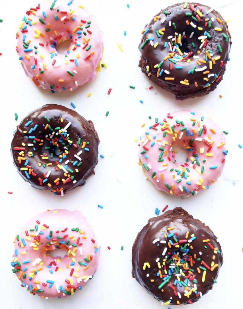 pink iced and chocolate iced gluten free donuts with multicolored sprinkles. 