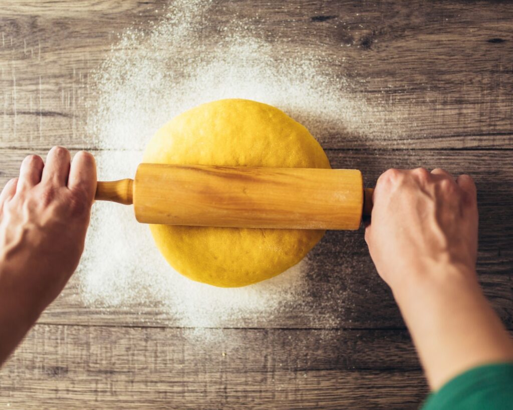 rolling out pasta dough with a rolling pin