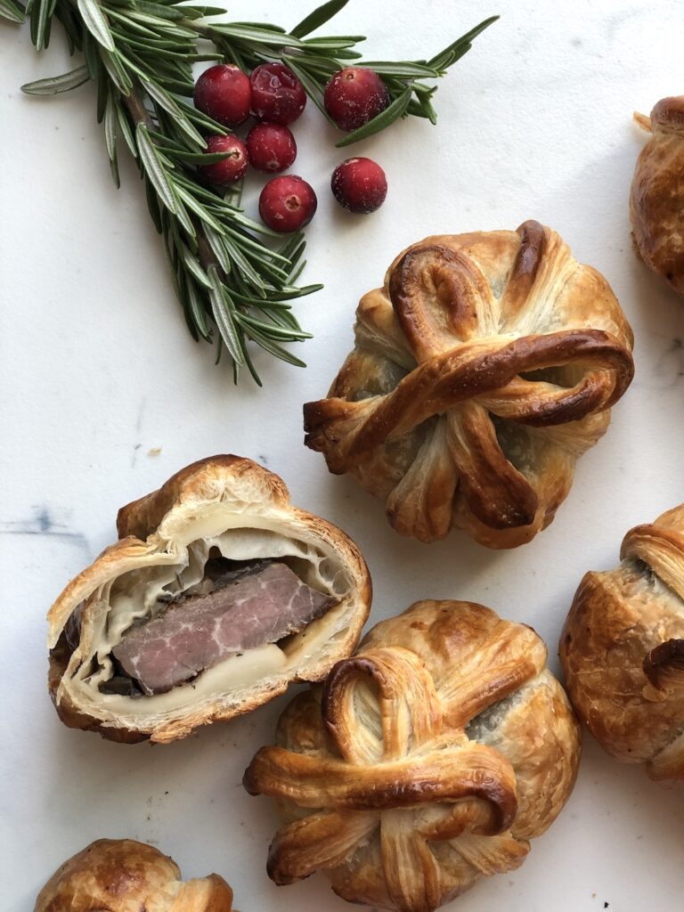 mini beef wellingtons with rosemary garnish