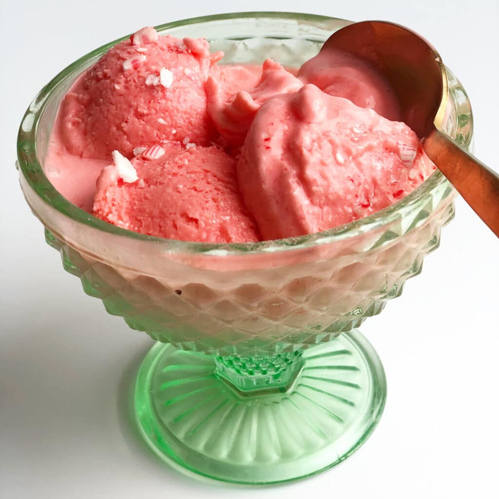 peppermint ice cream in a green glass cup with a gold spoon