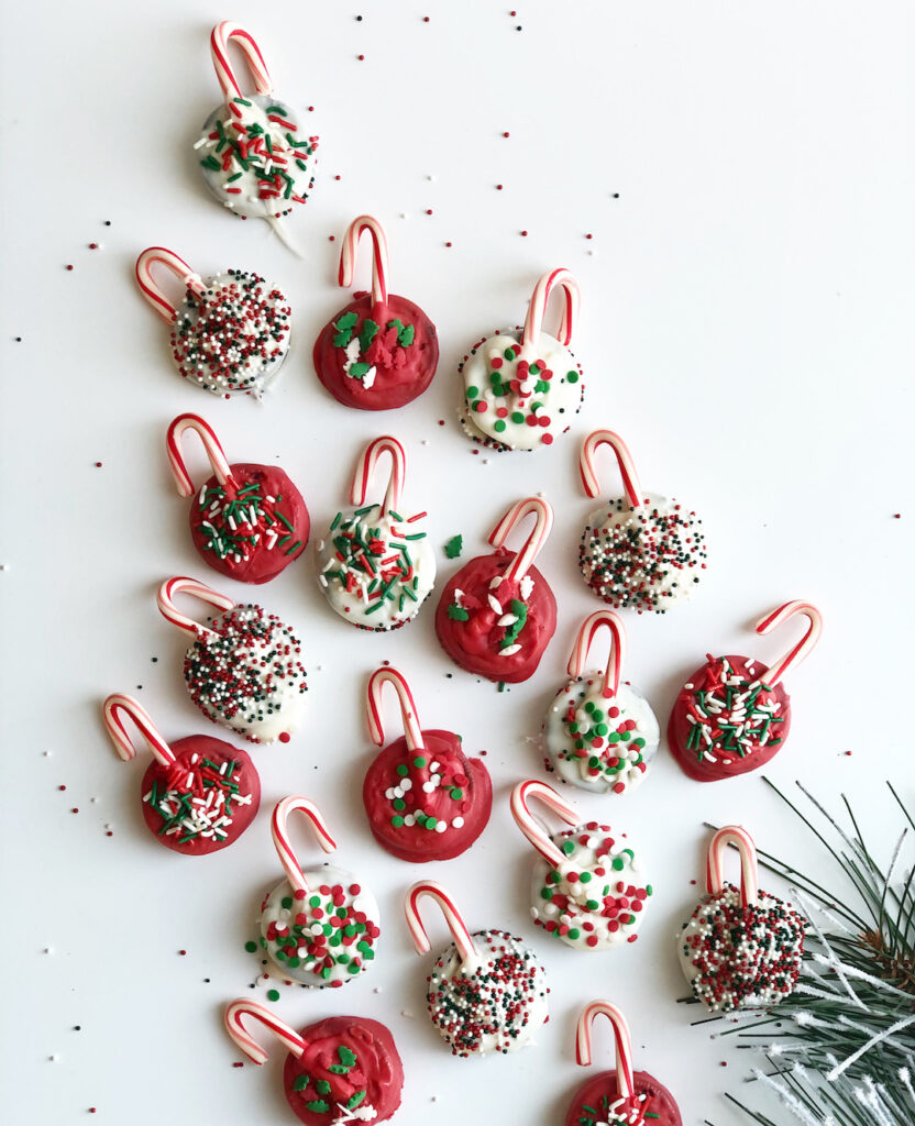 Oreo Christmas cookies that look like ornaments with candy canes and sprinkles